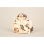 A Japanese ivory netsuke of a squat man with incised and painted decoration,