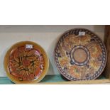 A Charlotte Rhead orange and floral tube lined charger plus a Poole Aegean plate