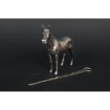 A silver skewer and a large white metal horse ornament