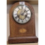 An Edwardian inlaid oak striking mantel clock
