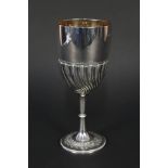 A large silver cup with half ribbed detail to body and embossed leaf detail to base,