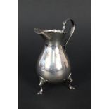 A silver cream jug with wavy rim,