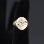 A 9ct gold signet ring set with three small garnets,