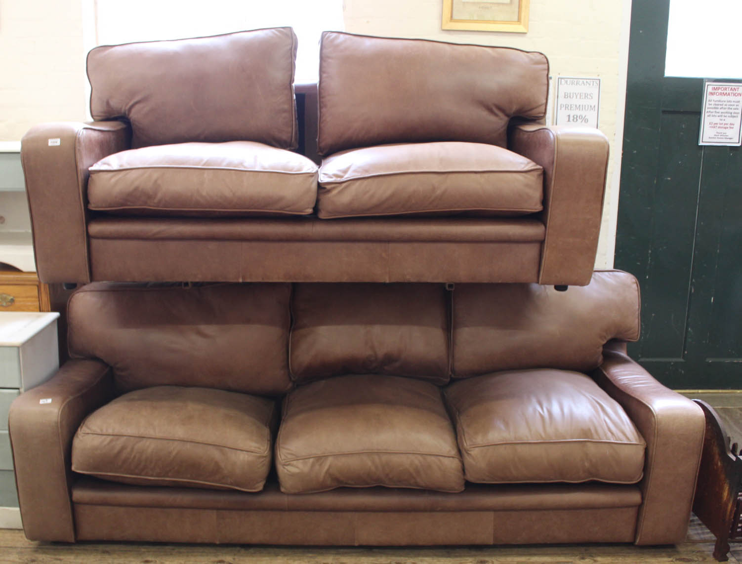 A substantial brown leather three seater sofa and a matching two seater sofa