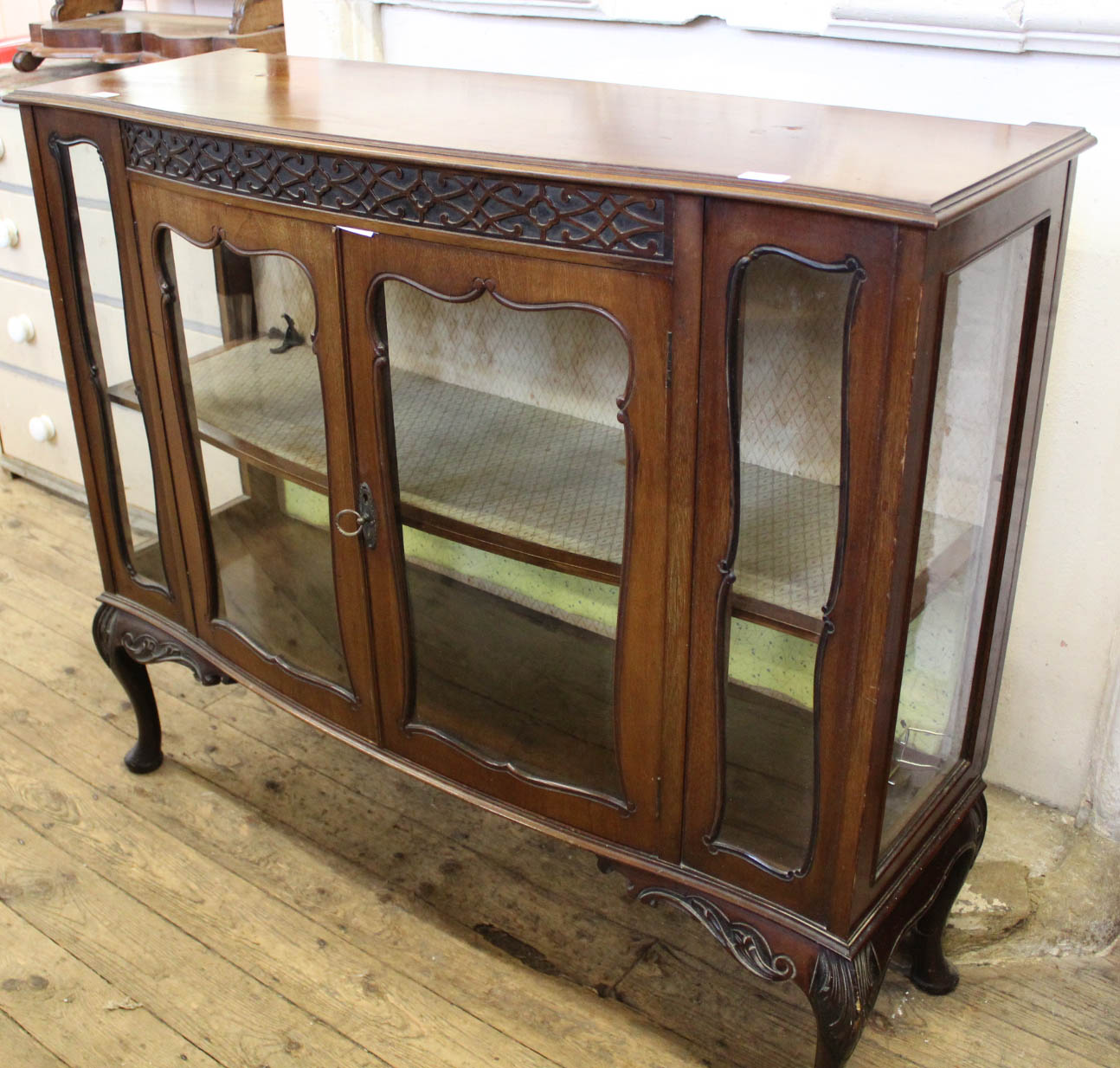 An 1930's shaped front glazed display cabinet