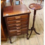 A 1920's mahogany six drawer music cabinet and a plant stand