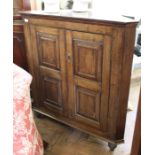 A Georgian oak two door corner cupboard on fluted feet