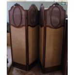 An Edwardian four panel screen with carved and rattan decorated tops