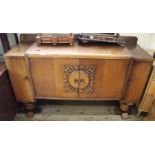 A 1930's oak sideboard with four drawers and carved decoration to front