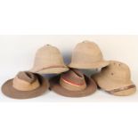 Two 'Wolseley' cork helmets with a British Army pith helmet and two military slouch hats,