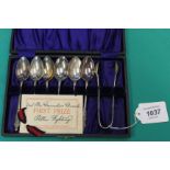 A set of six silver plate teaspoons and sugar tongs with 'First Prize Card',