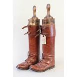 A pair of brown leather boots (early 20th Century) with a pair of period boot jacks