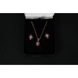 A ruby and diamond 9ct gold cluster pendant on chain with matching earrings
