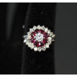 A white gold or platinum diamond and ruby cluster ring in flower type setting,