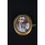 A large yellow metal mounted shell cameo brooch/pendant with carved village scene