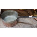 A heavy 19th Century seamed copper saucepan, stamped 'Lent by Temple & Crook' with iron handle,