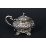 A William IV silver mustard pot of bulbous form with embossed decoration throughout on four feet