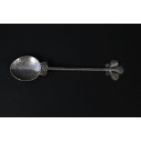 A silver Arts & Crafts style spoon with ornate leaf design to stem, hand planished by Hugh Wallis,