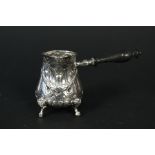 An embossed silver brandy jug with ebonised handle, 930 marked to base,