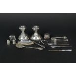 A mixed silver and white metal items including a pair of dwarf candlesticks (as found),