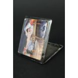 A silver cigarette case with enamelled scene of a nude lady lying in a bed to front (there are