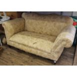 A cream upholstered two seater day bed with drop end