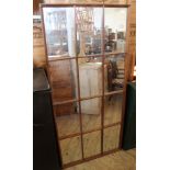 A large oak framed mirror in the style of a French window