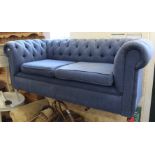 A blue upholstered Chesterfield style two seater sofa