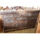 A heavily carved oak sideboard with Greenman decoration