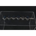 A silver bracelet set with six large blue stones