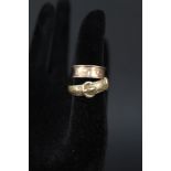 A 9ct gold buckle ring with foliate decoration and another 9ct gold ring (as found)