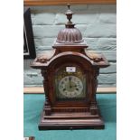 A carved mahogany striking mantel clock