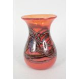 An orange glass vase with swirl design,