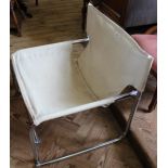 A chrome lounge chair with cream fabric upholstery