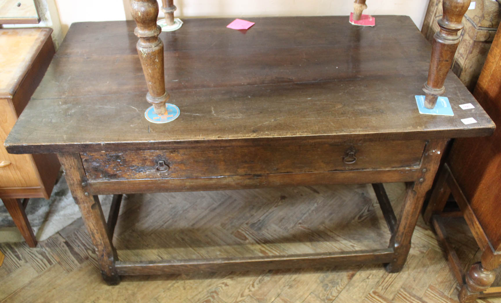 An early 18th Century oak stretcher table with later added top