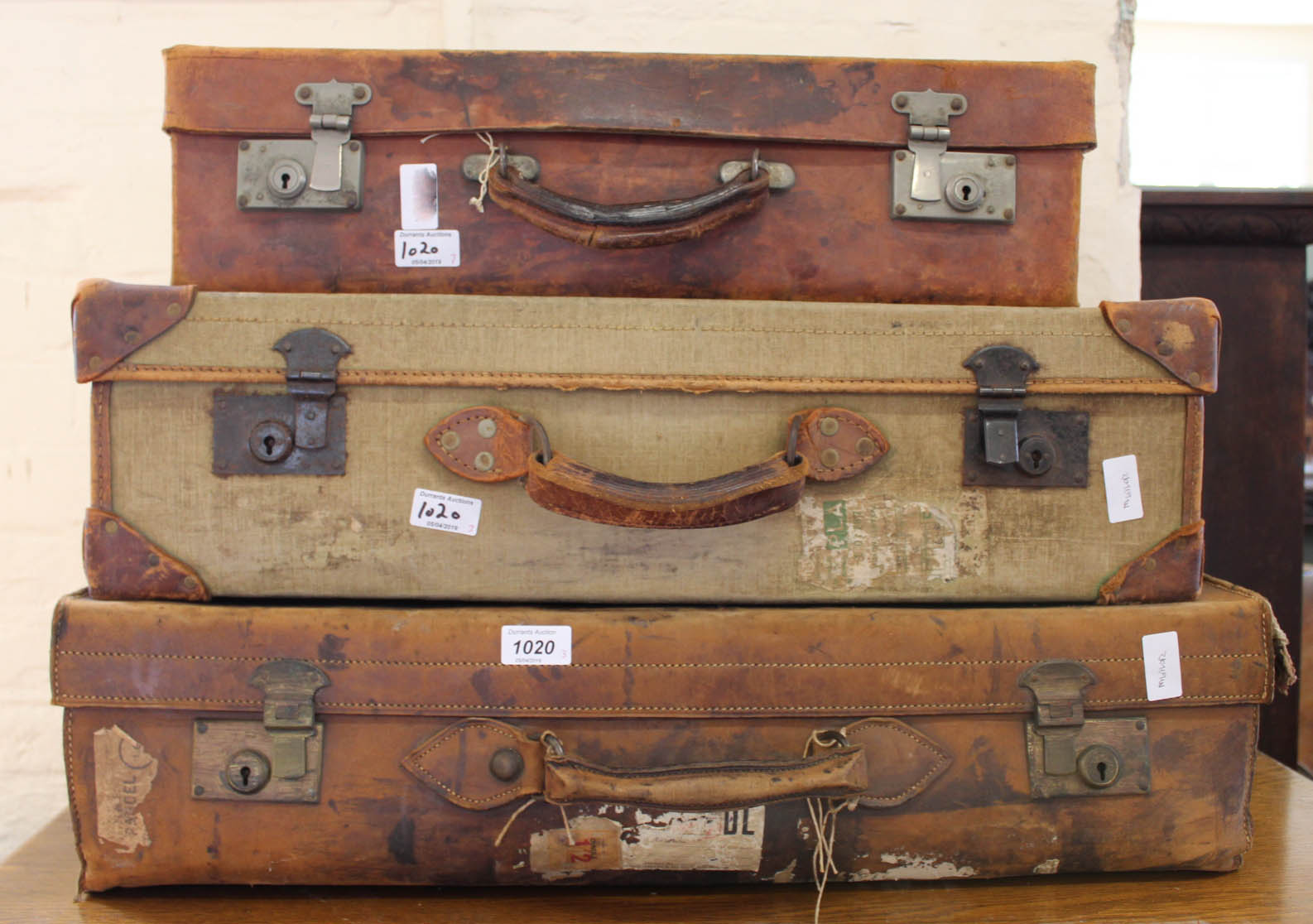 Three vintage suitcases of graduating sizes