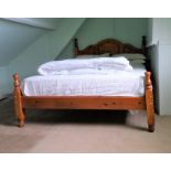 A dark stained pine double bed frame