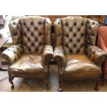 A pair of reproduction leather wingback armchairs