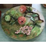 A pottery plate with relief fruit decoration,