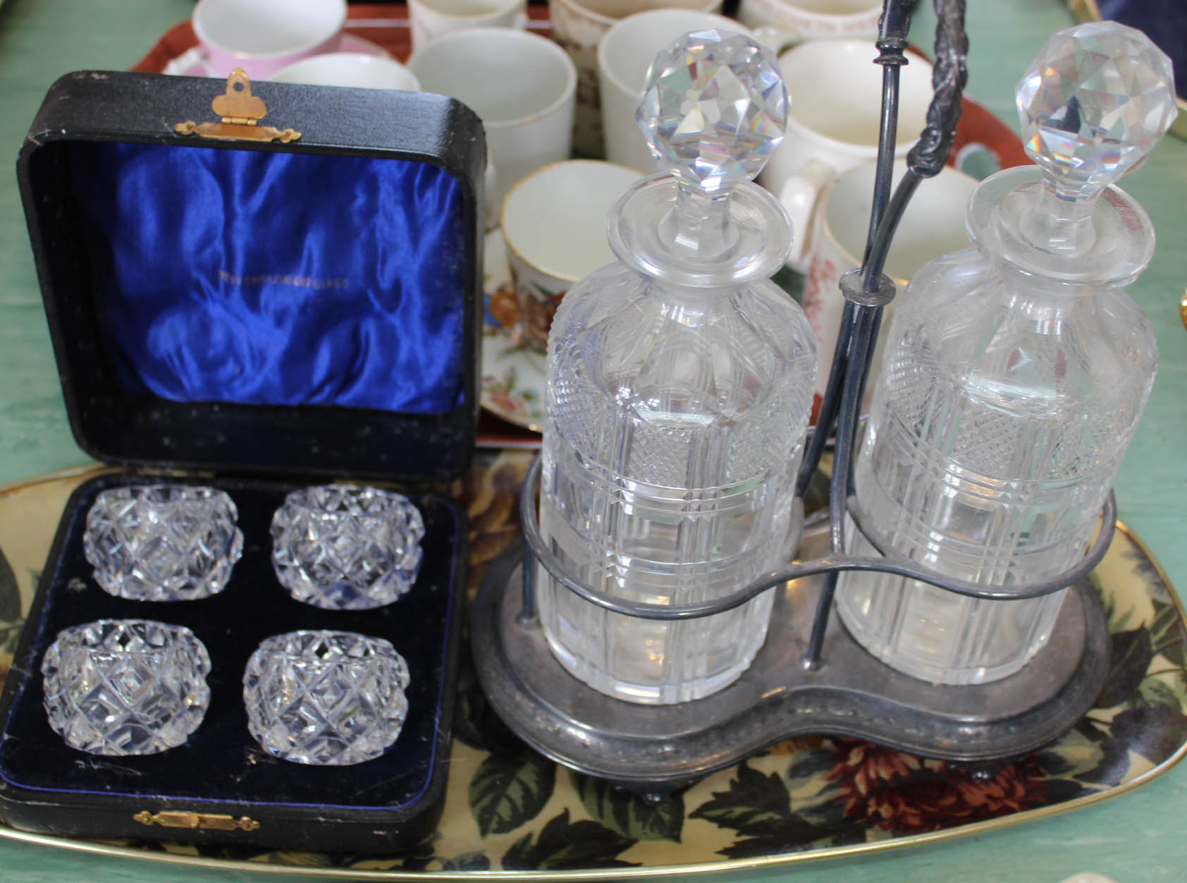 A silver plated stand with two cut glass decanters plus four case cut glass salts