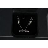 A 9ct white gold diamond set pendant on chain plus a pair of matching earrings