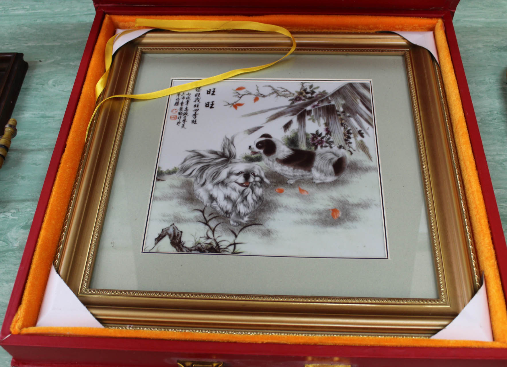 A cased Chinese porcelain plaque of two dogs,