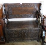 A 1920's carved oak monks bench with lift up seat