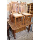 An Edwardian oak extending dining table plus four upholstered chairs