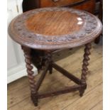 A late Victorian carved oak round table with barley twist legs