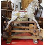 A 19th Century decorative rocking horse in distressed finish on pine stand