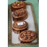 Four Victorian oval copper jelly moulds with finger style surrounds and raised decoration to the