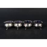 A set of four silver 'salts', all with blue glass liners,