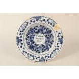 An 18th Century Dutch Delft plate with inscriptions to front and rear (chipped)
