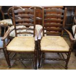 A pair of oak rush seated ladder back carvers